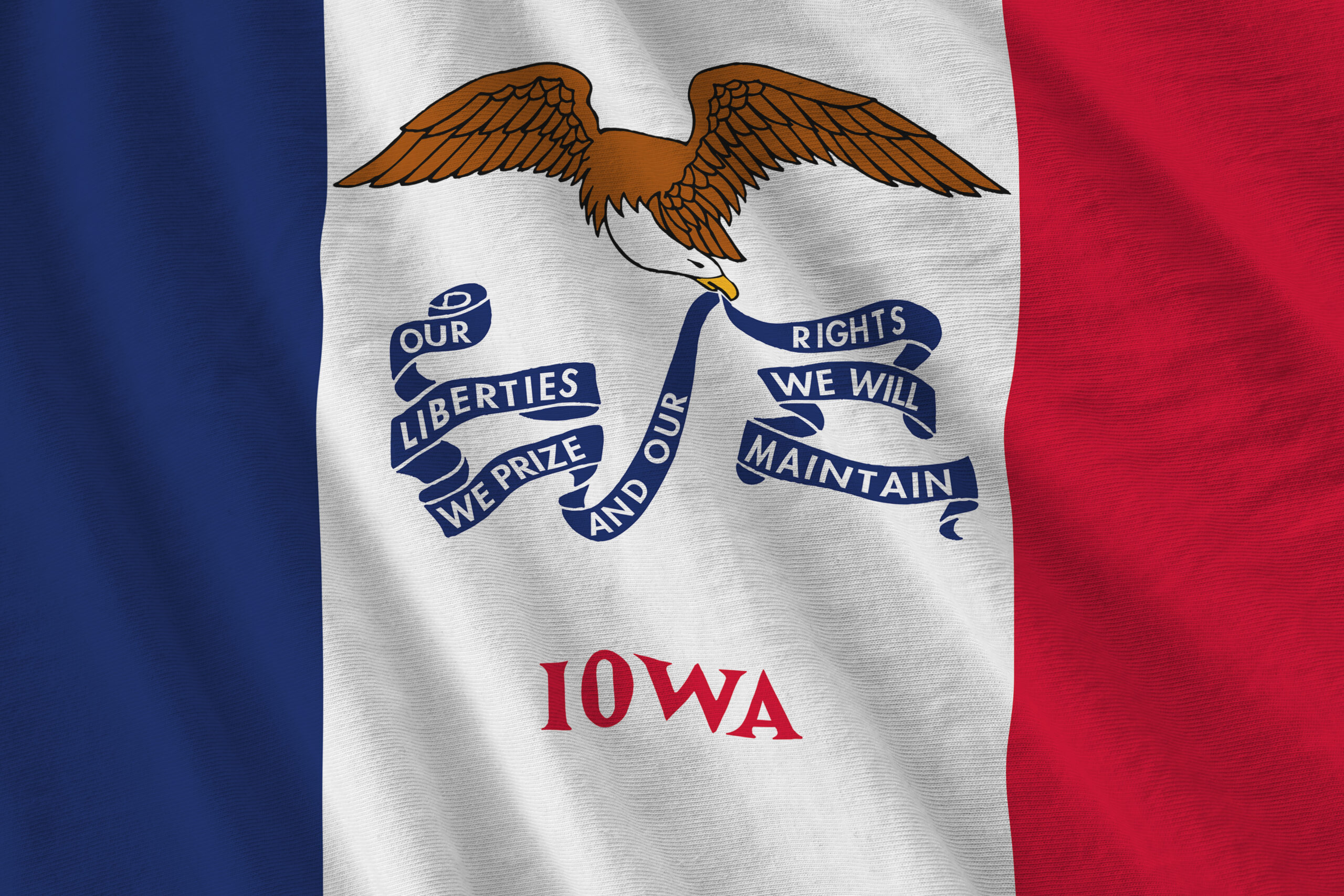 Iowa US state flag with big folds waving close up under the studio light indoors. The official symbols and colors in fabric banner